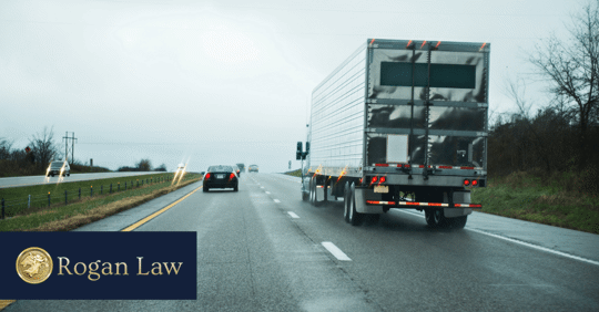 truck driving in cloudy weather next to small car